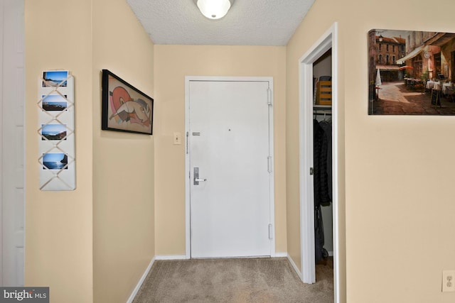 doorway to outside featuring a textured ceiling, baseboards, and light colored carpet