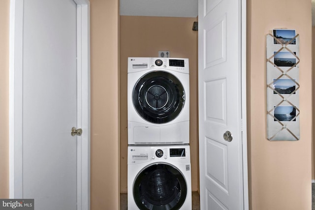 clothes washing area featuring stacked washer / drying machine and laundry area