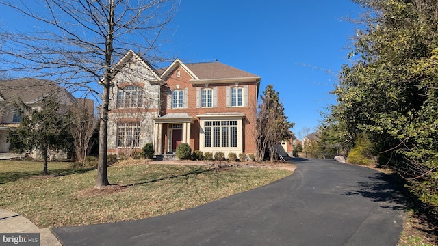 view of front of property with a front yard and brick siding