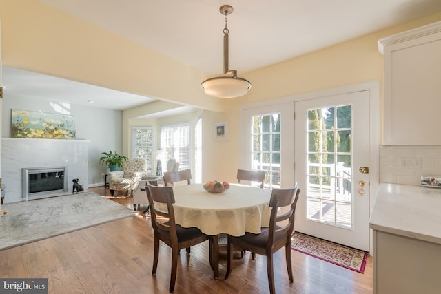 dining space with a fireplace and wood finished floors