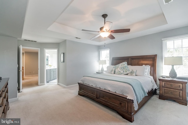 bedroom featuring light carpet, a raised ceiling, visible vents, and baseboards