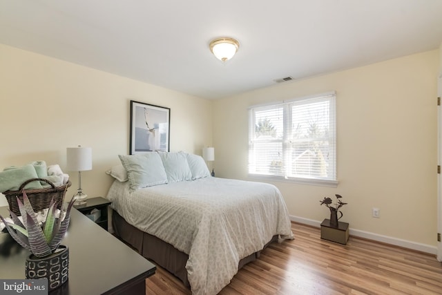 bedroom featuring baseboards, visible vents, and light wood-style floors