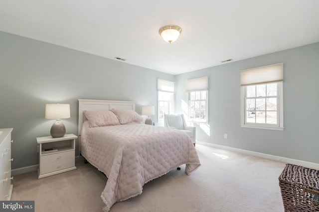 bedroom featuring light carpet, baseboards, multiple windows, and visible vents