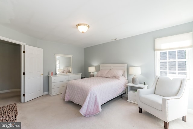 bedroom featuring baseboards, visible vents, and light colored carpet