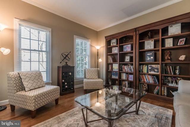 sitting room with ornamental molding, plenty of natural light, wood finished floors, and baseboards