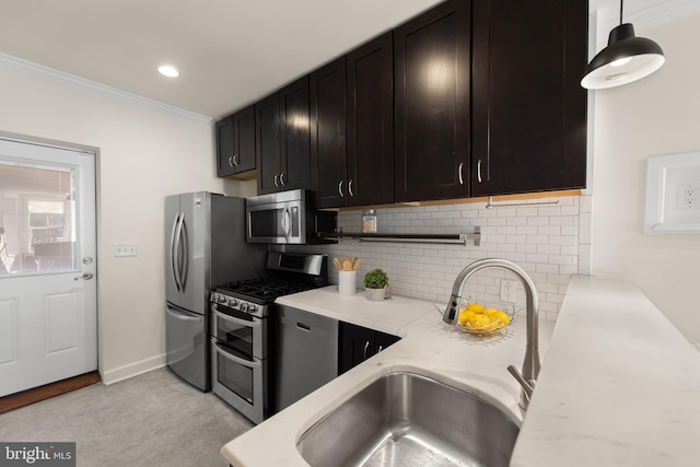 kitchen with stainless steel appliances, hanging light fixtures, a sink, and light stone counters