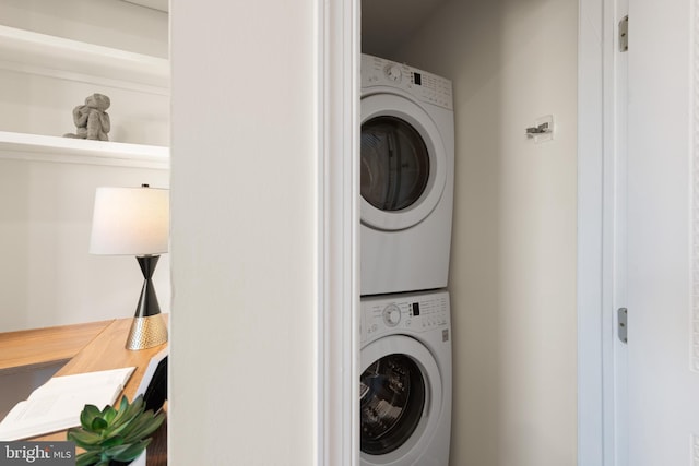 clothes washing area with stacked washer and dryer and laundry area