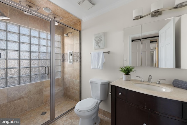 bathroom featuring visible vents, toilet, crown molding, vanity, and a shower stall