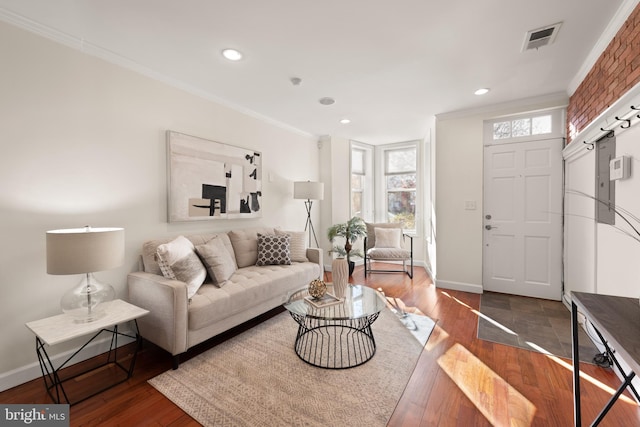 living area featuring dark wood finished floors, visible vents, crown molding, and baseboards