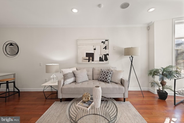 living area with baseboards, recessed lighting, dark wood finished floors, and crown molding