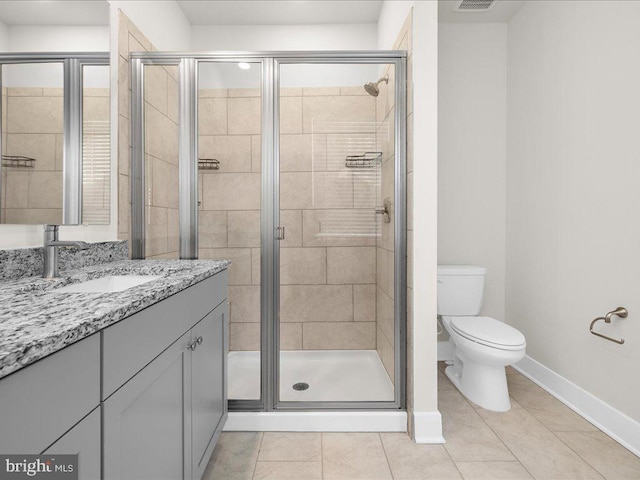 bathroom featuring baseboards, toilet, tile patterned flooring, vanity, and a shower stall