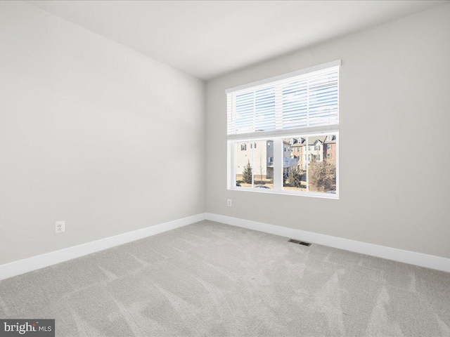 carpeted spare room with baseboards and visible vents