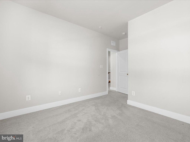 unfurnished room with light colored carpet, visible vents, and baseboards