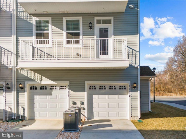 view of front of property with a garage, central AC unit, and concrete driveway