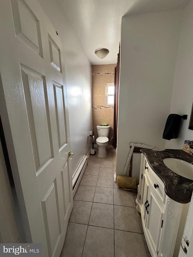 bathroom featuring a baseboard heating unit, vanity, toilet, and tile patterned floors