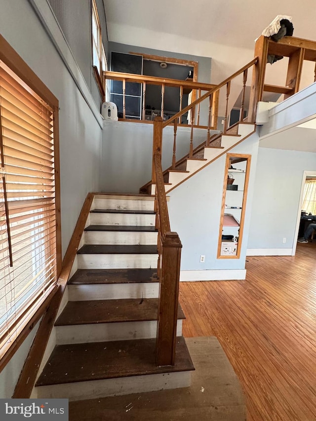 stairway with baseboards and wood finished floors