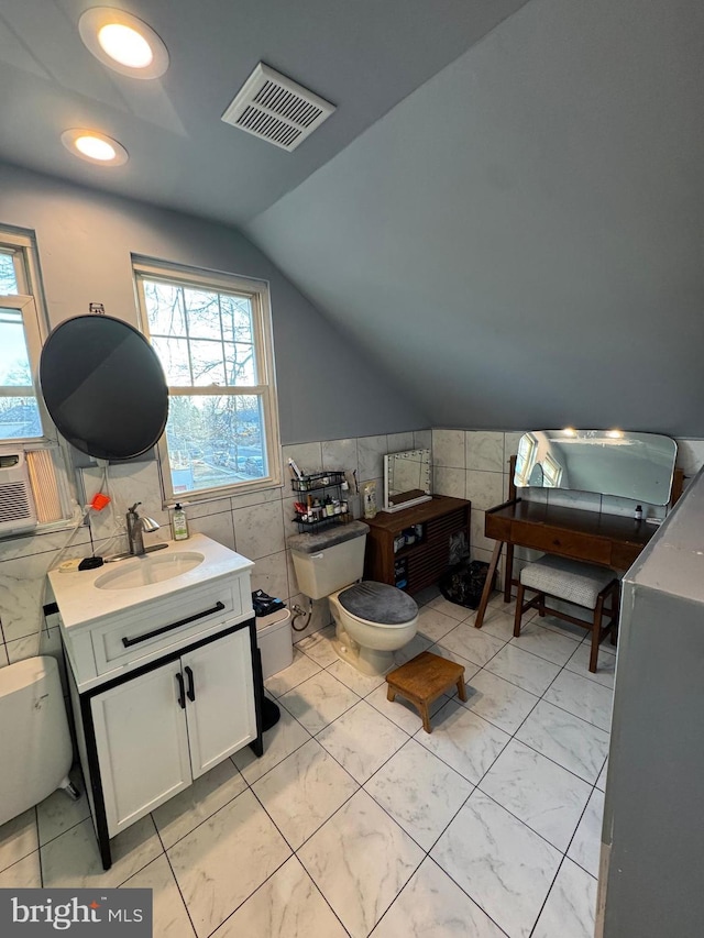 home office with a healthy amount of sunlight, a sink, visible vents, and tile walls