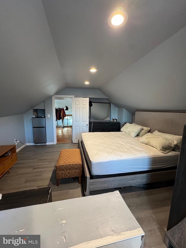 bedroom with lofted ceiling, recessed lighting, wood finished floors, baseboards, and freestanding refrigerator