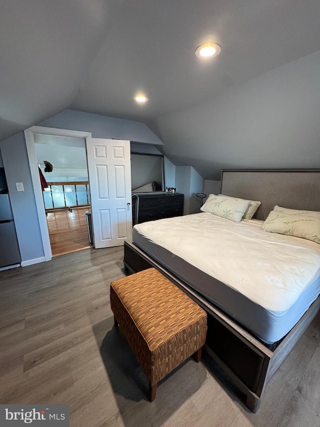 bedroom featuring vaulted ceiling, wood finished floors, and recessed lighting