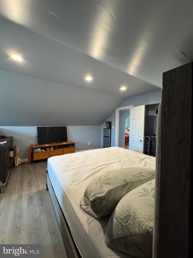 bedroom featuring vaulted ceiling, wood finished floors, and recessed lighting