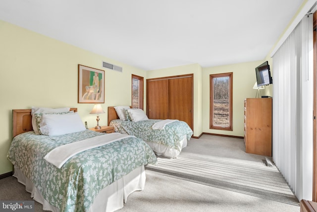 bedroom featuring light carpet, baseboards, visible vents, and a closet