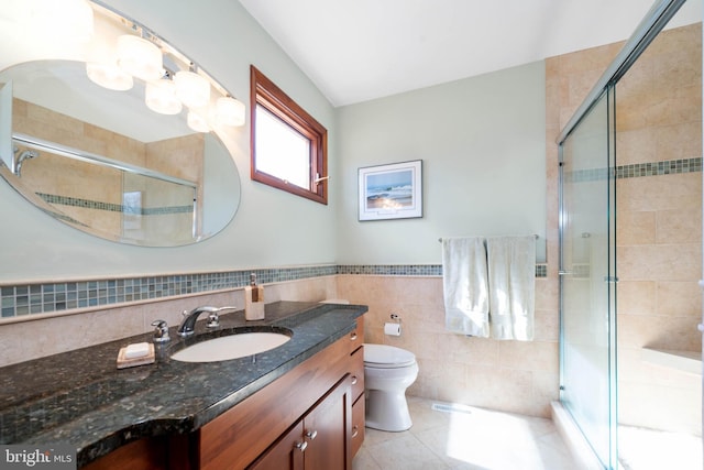 full bath featuring tile walls, toilet, a shower stall, vanity, and tile patterned flooring