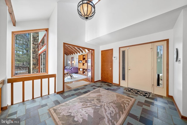 entrance foyer with stone tile flooring and baseboards