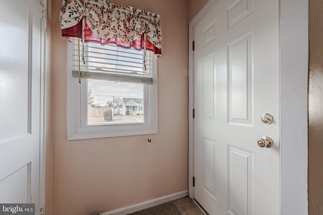 doorway featuring baseboards and tile patterned floors