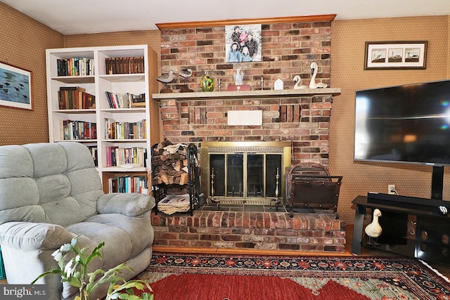 living room with a fireplace and wallpapered walls