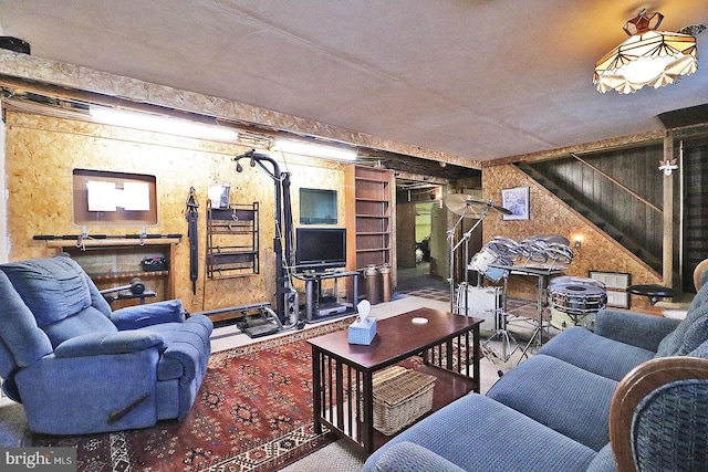 living room featuring wooden walls and stairs