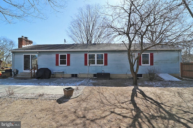 back of property featuring entry steps, a patio area, and a chimney