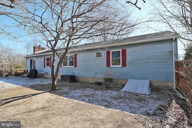 back of property featuring fence and a chimney