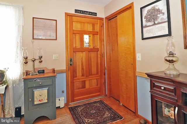 foyer entrance with a baseboard radiator and a healthy amount of sunlight