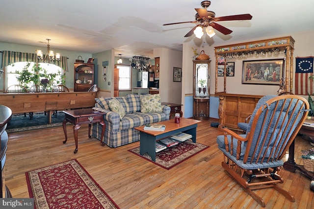 living room featuring light wood-style floors and ceiling fan with notable chandelier