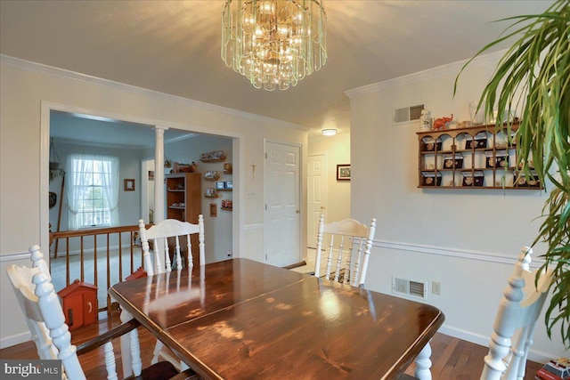 dining room featuring visible vents, crown molding, and wood finished floors
