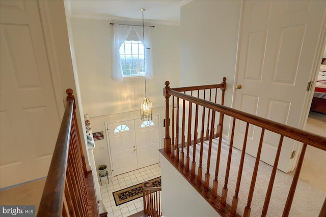 stairs featuring ornamental molding and a notable chandelier