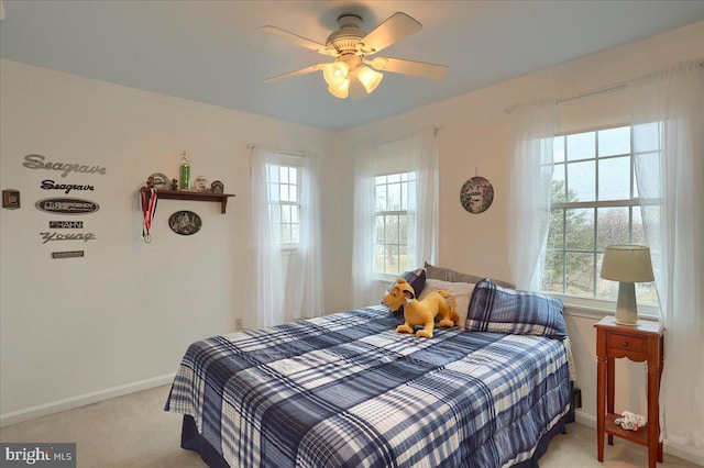 bedroom with baseboards, multiple windows, and light carpet