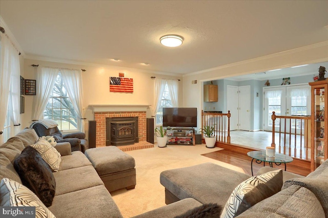 carpeted living room featuring crown molding, a brick fireplace, and french doors