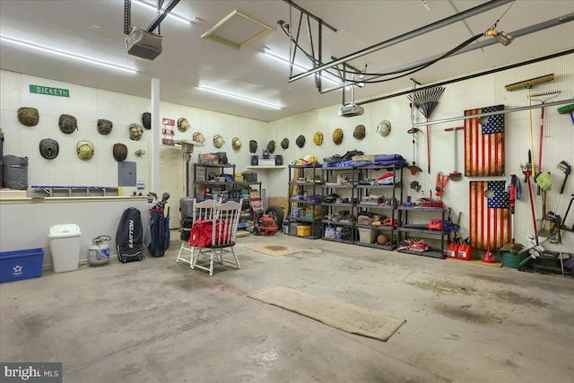 garage featuring a workshop area, a garage door opener, and electric panel