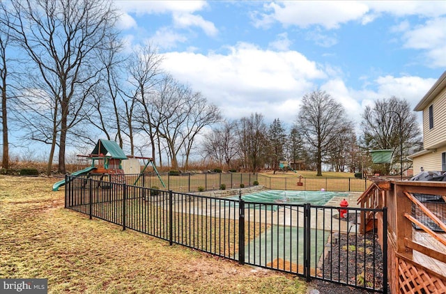 view of swimming pool with a lawn, fence, a fenced in pool, and a playground