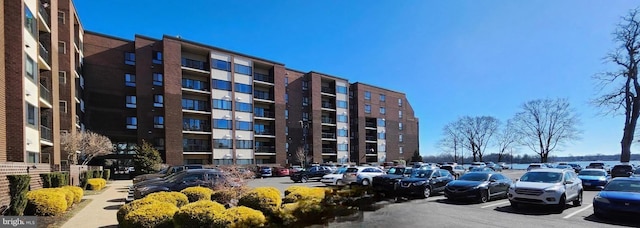 view of apartment building / complex featuring uncovered parking