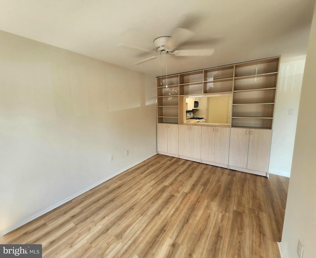 spare room featuring a ceiling fan, wood finished floors, and baseboards