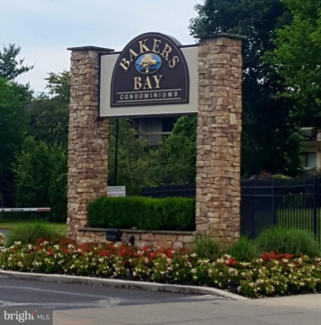 community / neighborhood sign featuring fence