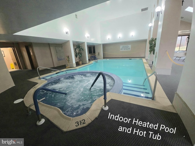 view of swimming pool featuring an in-ground hot tub
