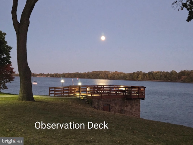 dock area featuring a water view and a lawn