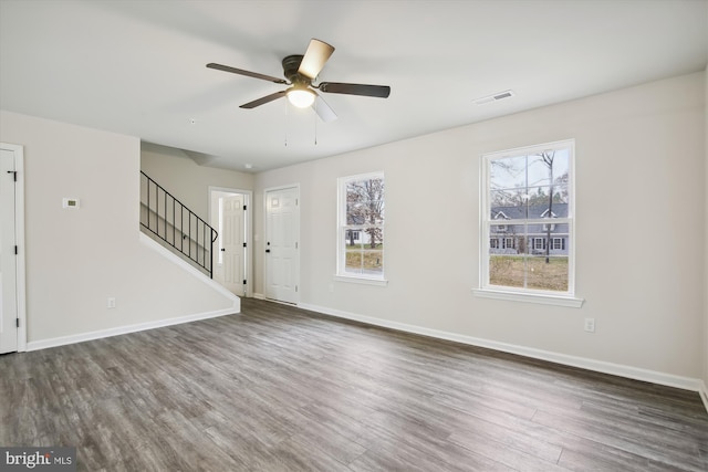 interior space featuring baseboards, visible vents, stairway, and dark wood-type flooring