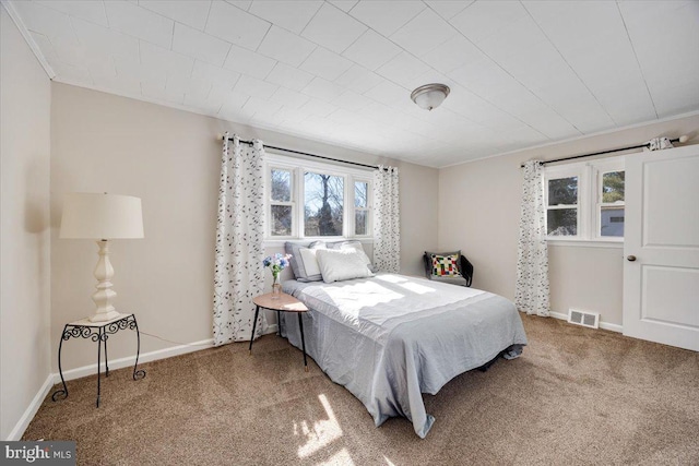 carpeted bedroom featuring baseboards and visible vents