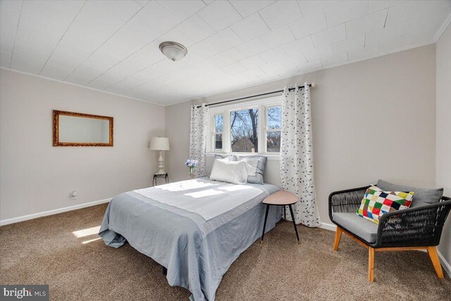 carpeted bedroom featuring ornamental molding and baseboards