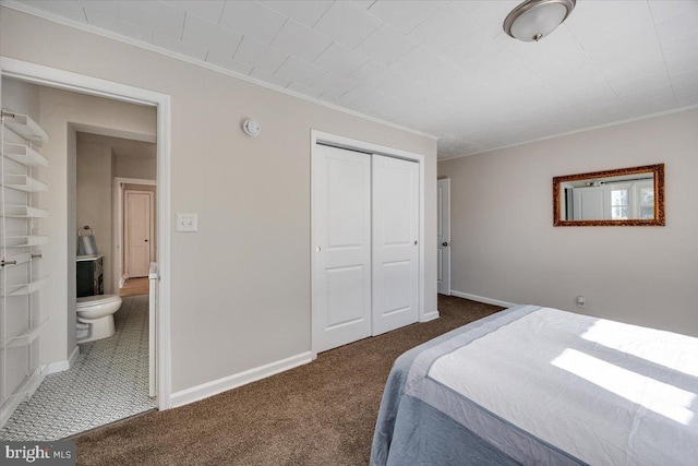 bedroom featuring ornamental molding, a closet, dark carpet, and baseboards