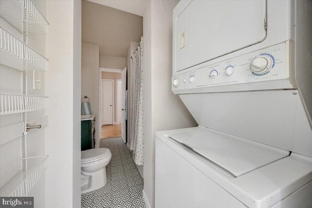 clothes washing area with stacked washer / dryer and laundry area